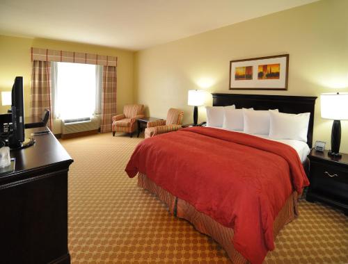A bed or beds in a room at Country Inn & Suites by Radisson, Conway, AR