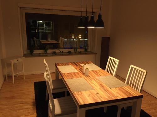 mesa de comedor con sillas blancas y mesa de madera en Ferien- Monteurswohnung, en Brunsbüttel