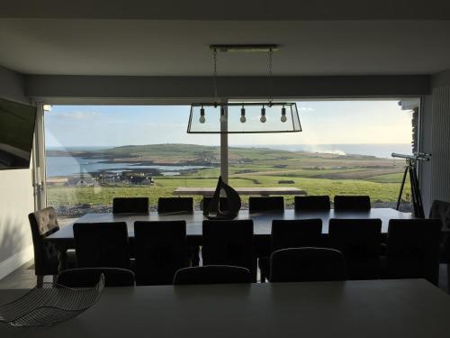 a room with a table and chairs and a large window at Ocean View,Kinsale, Hosted by Exquisite holiday homes, sleeps 22 in Kinsale