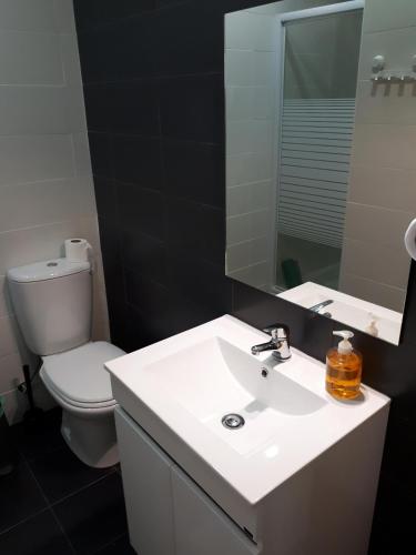a bathroom with a sink and a toilet and a mirror at Casa do Centro in Marinha Grande