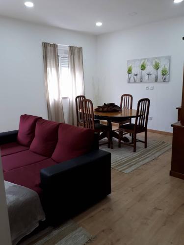 a living room with a purple couch and a table at Casa do Centro in Marinha Grande