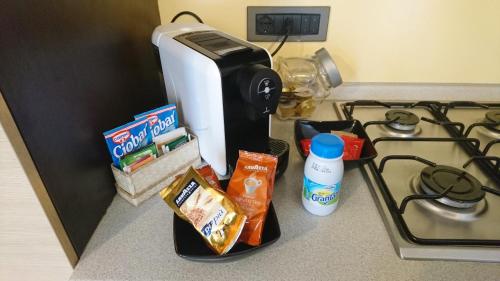 a counter top with a coffee maker and some food at La trifula bianca apts. in Alba