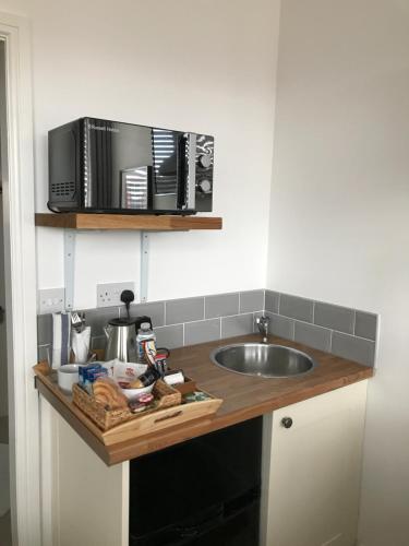 a kitchen counter with a sink and a microwave at The Larches in Wolverhampton