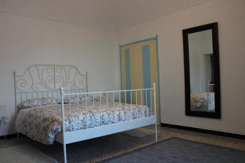 a bedroom with a white bed and a mirror at La Villa di Pa' in Villadeati