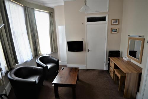 a living room with a couch and a chair and a table at The Gateway Hotel in London