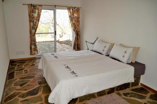 A bed or beds in a room at Halala Africa Lodge - Eagle Rock Lodge