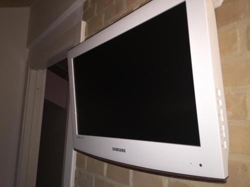 a flat screen television hanging on a brick wall at Residence La Nave in Senigallia