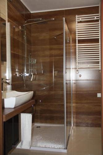a bathroom with a glass shower and a sink at Apartament Tabaco in Łódź