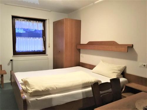 ジンスハイムにあるGasthaus Löwenのベッド2台と窓が備わる小さな客室です。