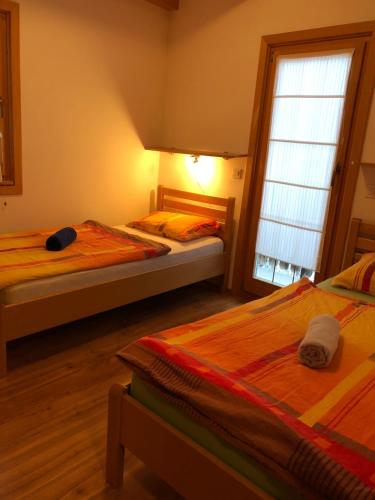 1 dormitorio con 2 camas y ventana en Apartmaji Zlata Lisička en Cerkno