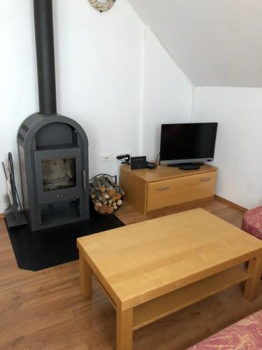 a living room with a wood stove and a table at Apartmaji Zlata Lisička in Cerkno