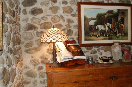 a lamp on a table with books and a painting at Villa Solaria in Orvieto
