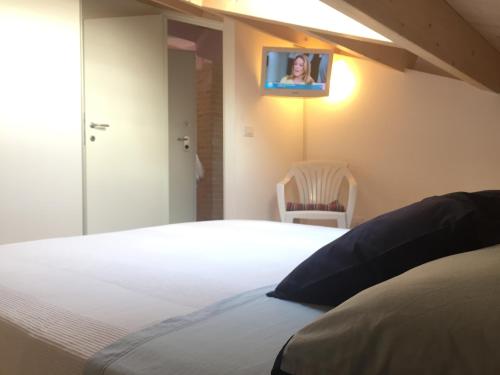 a bedroom with a bed with a tv on the wall at Residence La Nave in Senigallia
