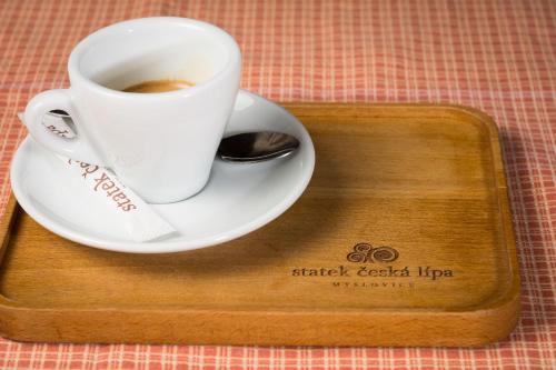 a cup of coffee sitting on a wooden tray at Statek česká lípa Myslovice in Klatovy