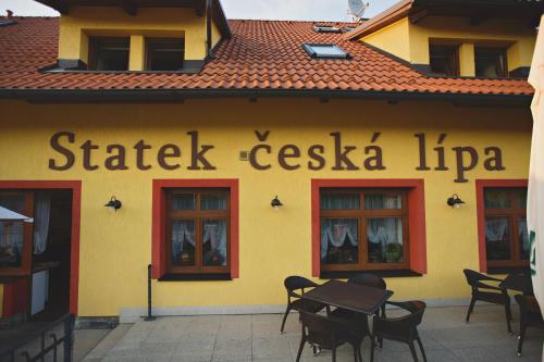 a yellow building with a table in front of it at Statek česká lípa Myslovice in Klatovy