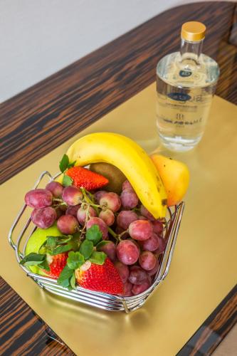 a bowl of fruit on a table with a bottle of water at Hotel MeraPrime Gold Lisboa in Lisbon