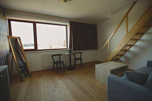 a living room with a staircase and a table and chairs at Statek česká lípa Myslovice in Klatovy