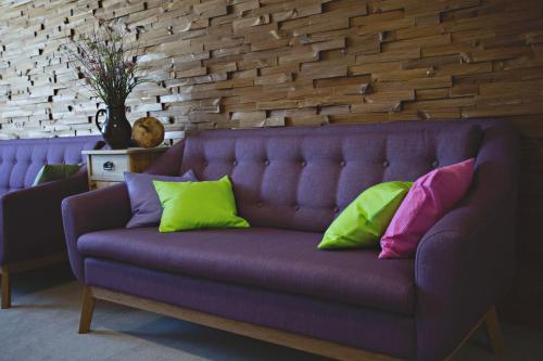 a purple couch with four colorful pillows on it at Statek česká lípa Myslovice in Klatovy