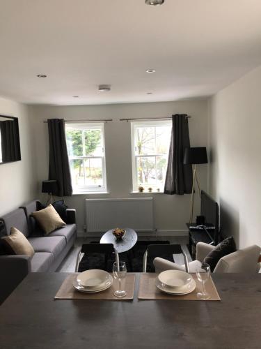 a living room with a table and a couch at Portfolio Apartments - St Albans City Centre in St. Albans