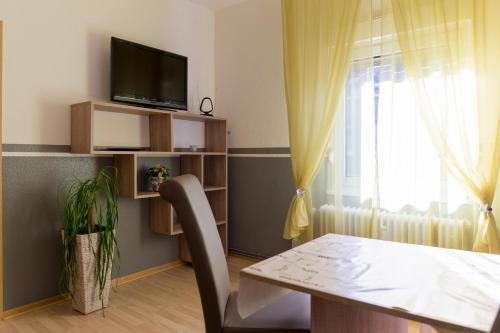a dining room with a table and a tv and a window at Apartment Widey Str. 52 in Witten