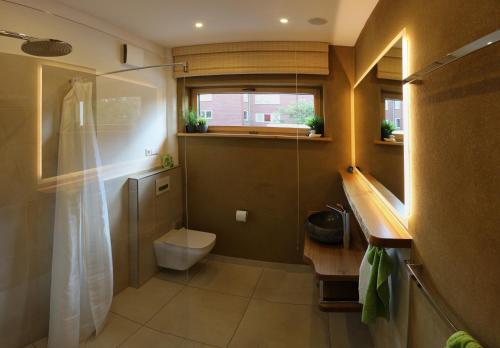 een badkamer met een toilet, een wastafel en een raam bij Ferienhaus Lüneburg in Lüneburg
