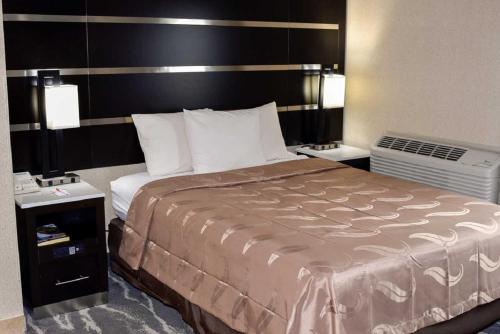 a hotel room with a large bed and two night stands at Quality Inn East Stroudsburg - Poconos in East Stroudsburg