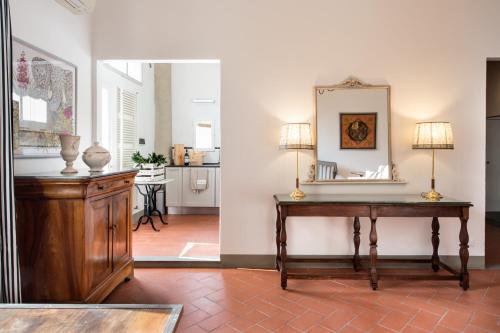 Una sala de estar con una mesa y un espejo. en BorgoDeGreci Apartments, en Florencia