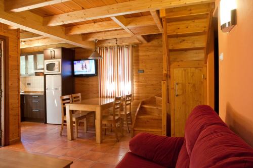 a kitchen and dining room with a table and chairs at Bungalows Verneda Mountain Resort in Arrós