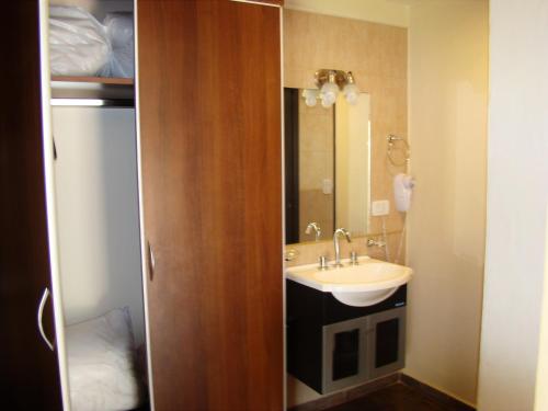La salle de bains est pourvue d'un lavabo et d'un miroir. dans l'établissement Apart Entrepiedras, à Merlo