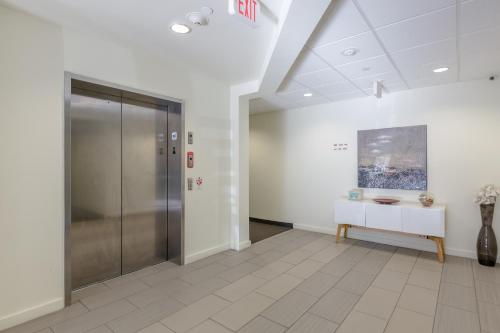 an office lobby with a glass door and a table at Sage Apartments Boston Logan Airport Chelsea in Chelsea