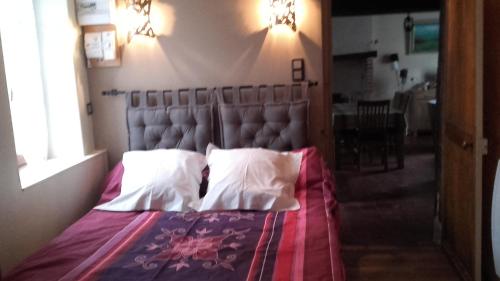 une chambre avec un grand lit avec deux oreillers dans l'établissement La Petite Maison, à Theillay