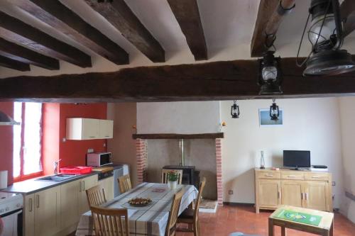 une cuisine et une salle à manger avec une table et des chaises dans l'établissement La Petite Maison, à Theillay