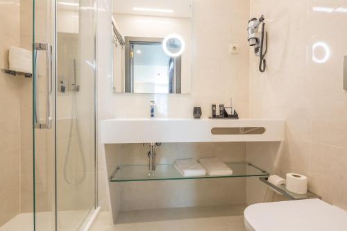 a bathroom with a sink and a shower at Hotel MeraPrime Gold Lisboa in Lisbon