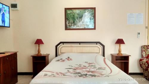una camera da letto con un letto, due tavoli e due lampade di Alpha Villa - Studios without kitchen a Flic-en-Flac