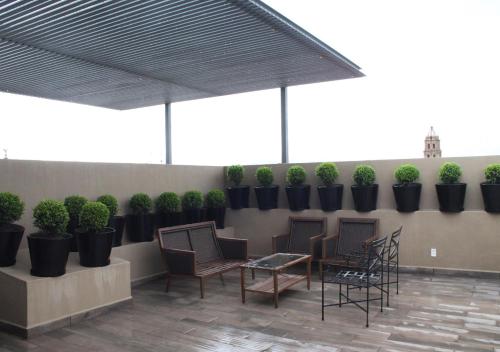 a patio with chairs and tables and potted plants at Gran Hotel Concordia San Luis Potosi in San Luis Potosí