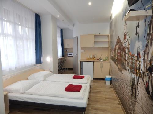 1 Schlafzimmer mit 2 Betten mit weißer Bettwäsche und roten Handtüchern in der Unterkunft Kálvin Vendégszobák in Debrecen