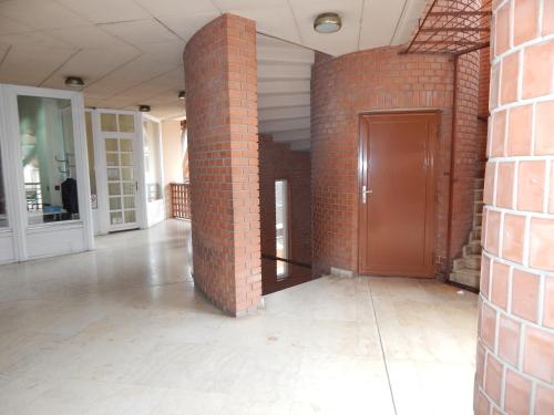 an empty room with a brick wall and a door at Kálvin Vendégszobák in Debrecen