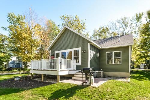 a green house with a deck and a grill at Four Generations in Saugatuck