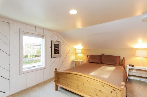 a bedroom with a wooden bed and a window at Hummingbird in Saugatuck