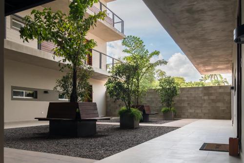 a courtyard with benches and trees in a building at START Villa Morra Rent Apartments in Asuncion