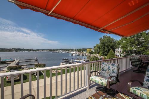 a balcony with chairs and a view of a river at Lay By The Bay in Saugatuck