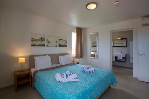 a bedroom with a bed with blue sheets and stuffed animals on it at Blue Bay Apartments in Sint Michiel