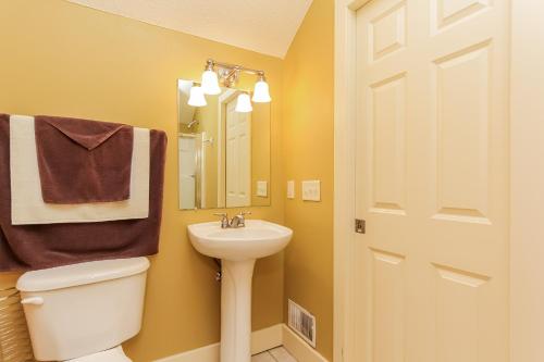 uma casa de banho com um lavatório, um WC e um espelho. em The Oriole em Saugatuck