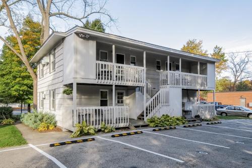 a white building with balconies and a parking lot at Water Street Retreat in Saugatuck