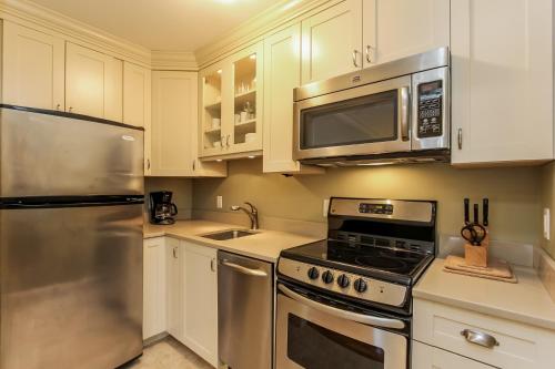 a kitchen with stainless steel appliances and white cabinets at Water Street Retreat in Saugatuck