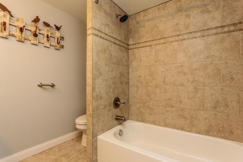 a bathroom with a tub and a toilet at Water Street Retreat in Saugatuck