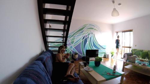 eine Gruppe von Menschen, die in einem Wohnzimmer auf einer Couch sitzen in der Unterkunft My Powderwave Ericeira in Ericeira