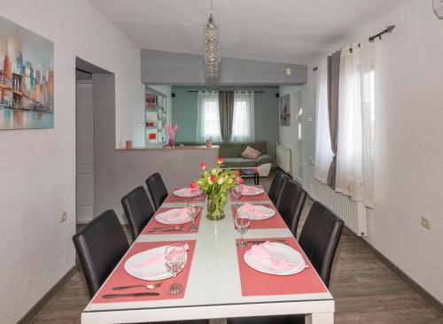 a dining room with a long table and chairs at Apartman Koko with private jacuzzi in Makarska