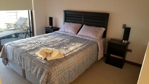 a bedroom with a bed with a hat on it at Apartamento Altos de Huayquique in Iquique