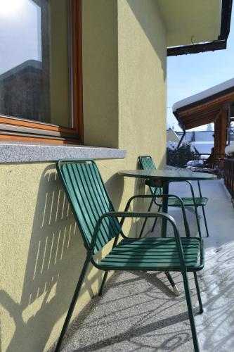 a green chair and a table on a patio at Durda in Poronin